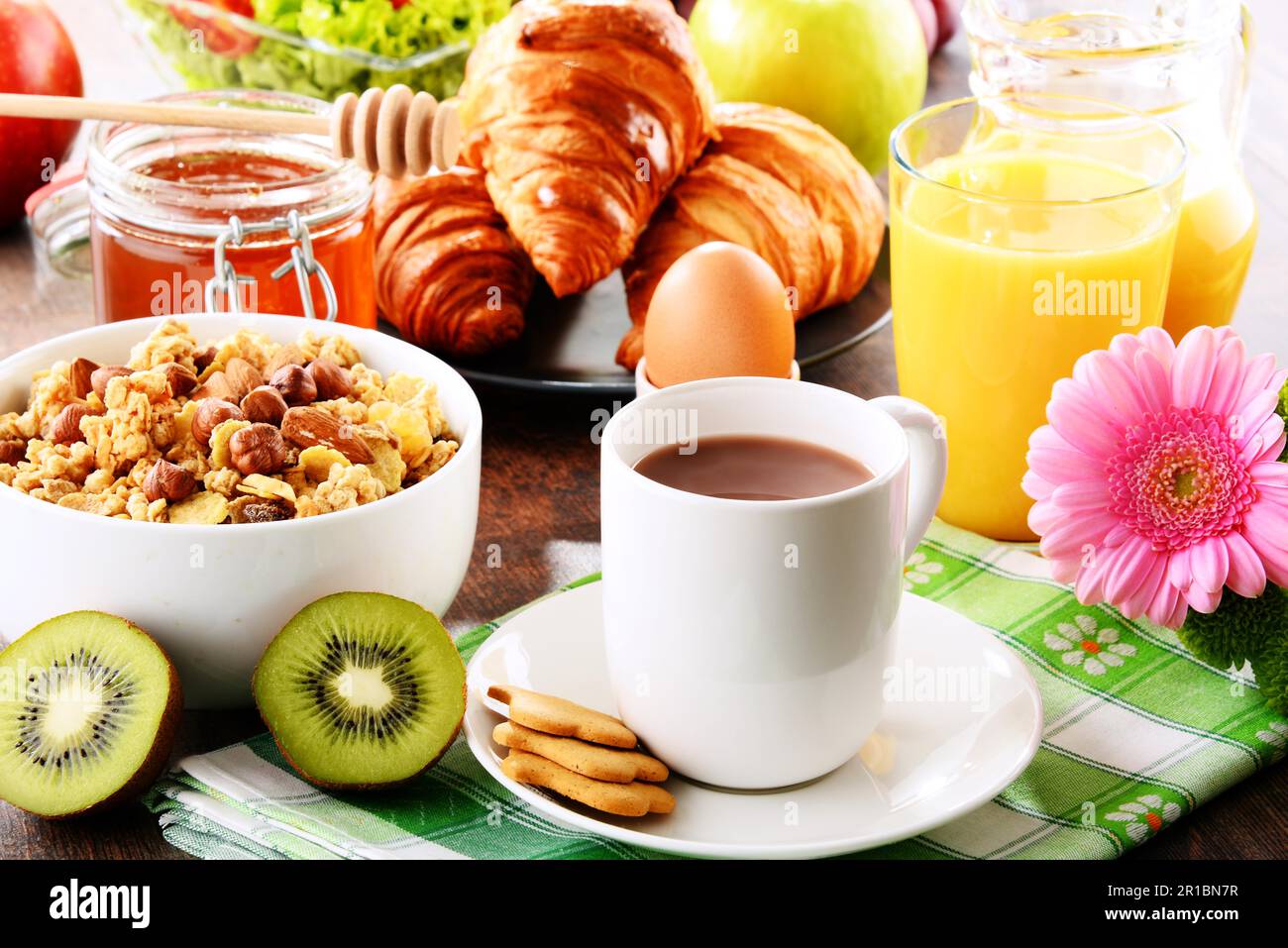 Das Frühstück, bestehend aus Obst, Orangensaft, Kaffee, Honig, Brot und Ei. Ausgewogene Ernährung Stockfoto