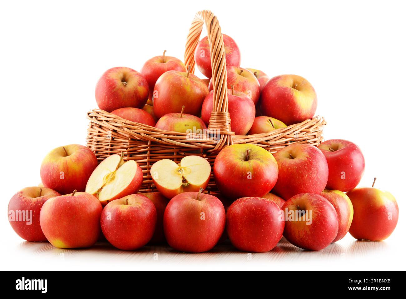 Äpfel im Weidenkorb isoliert auf weißem Hintergrund Stockfoto