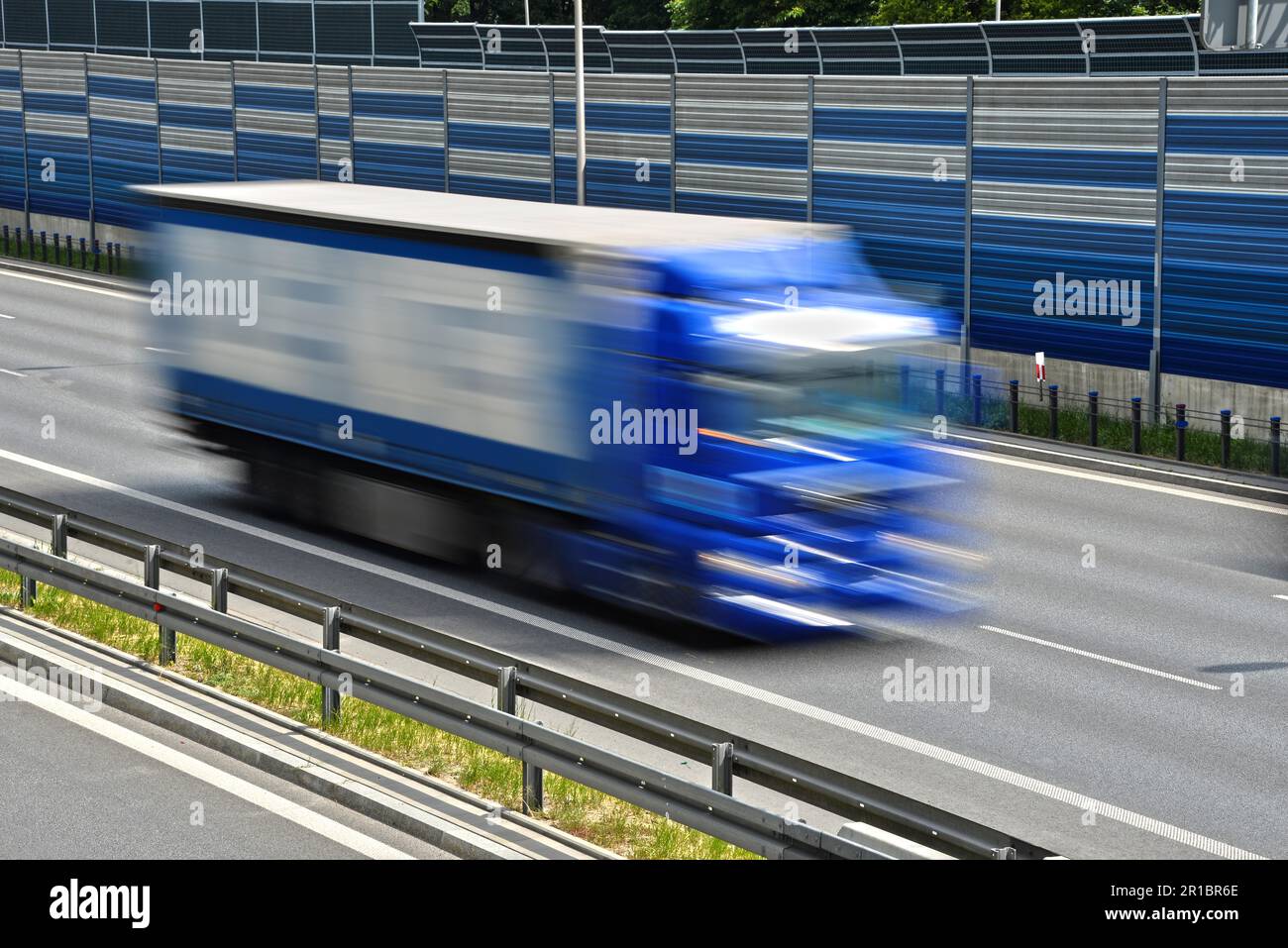 Großes Lastkraftwagen, das sich mit voller Geschwindigkeit auf einer sechsspurigen Zufahrtsstraße bewegt Stockfoto