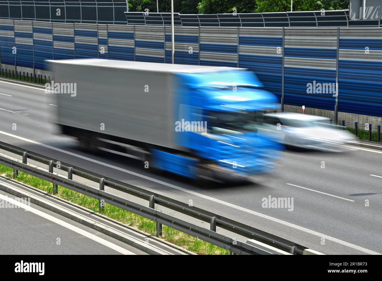 Großes Lastkraftwagen, das sich mit voller Geschwindigkeit auf einer sechsspurigen Zufahrtsstraße bewegt Stockfoto