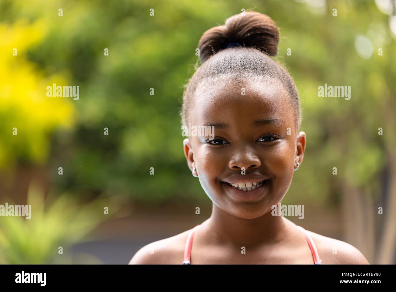 Porträt eines lächelnden afroamerikanischen Mädchens im Garten, mit Kopierraum Stockfoto