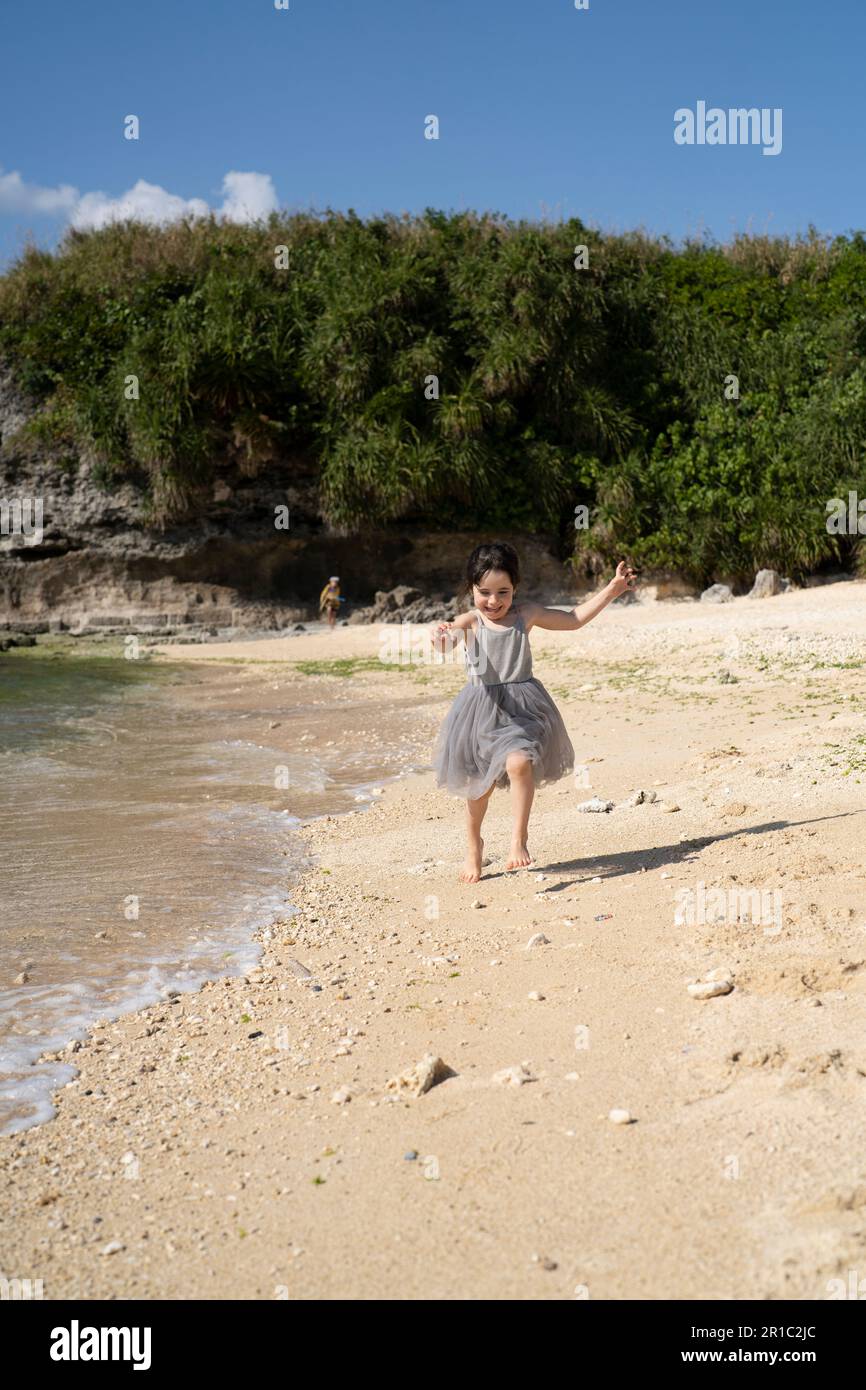 5-jähriges Mädchen, das an einem tropischen Strand spielt. Motobu, Okinawa, Japan Stockfoto