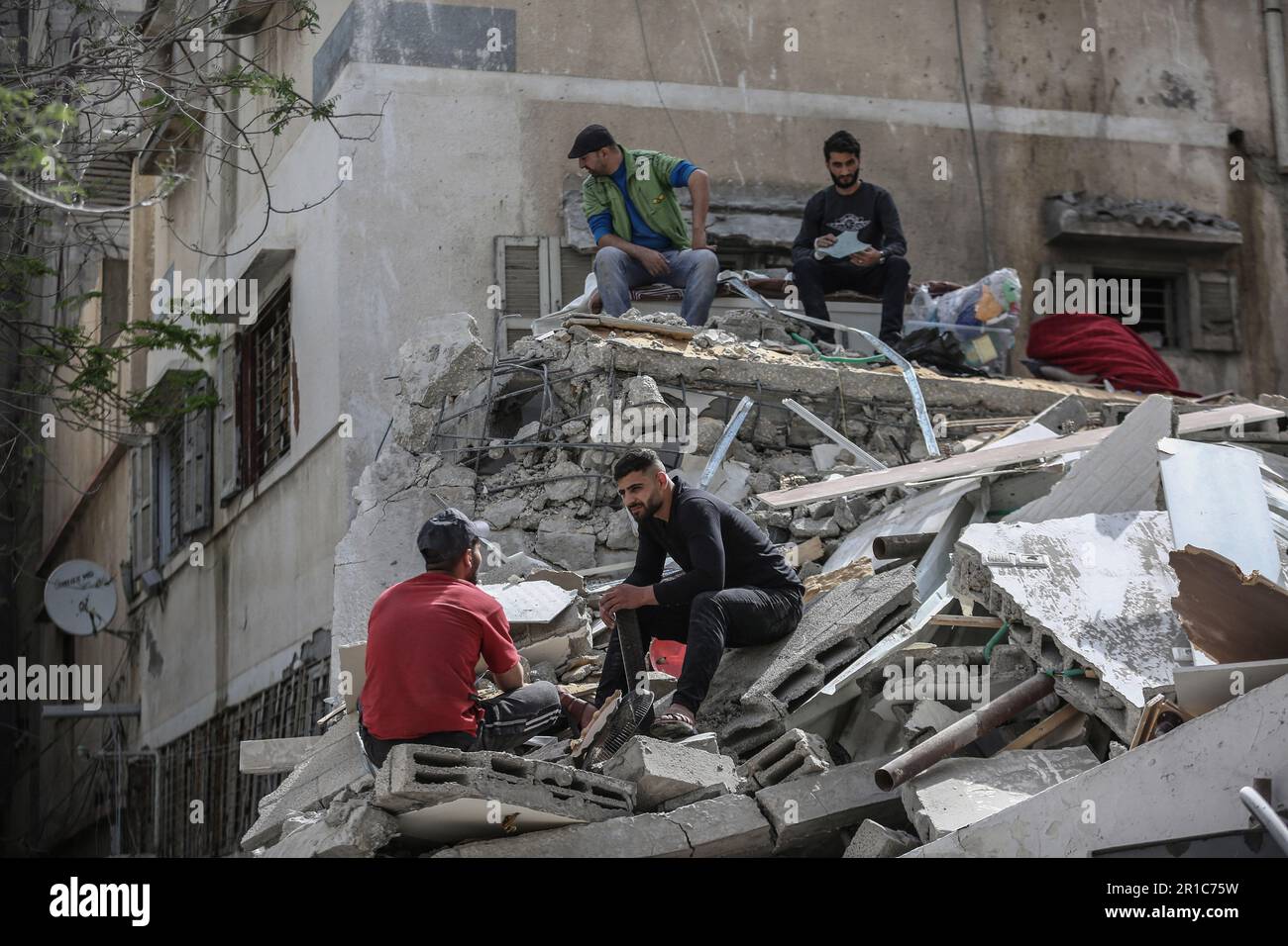 Gaza-Stadt, Palästinensische Gebiete. 13. Mai 2023. Palästinenser inspizieren ein zerstörtes Haus nach israelischen Streiks im Zentrum von Gaza. Kredit: Mohammed Talatene/dpa/Alamy Live News Stockfoto