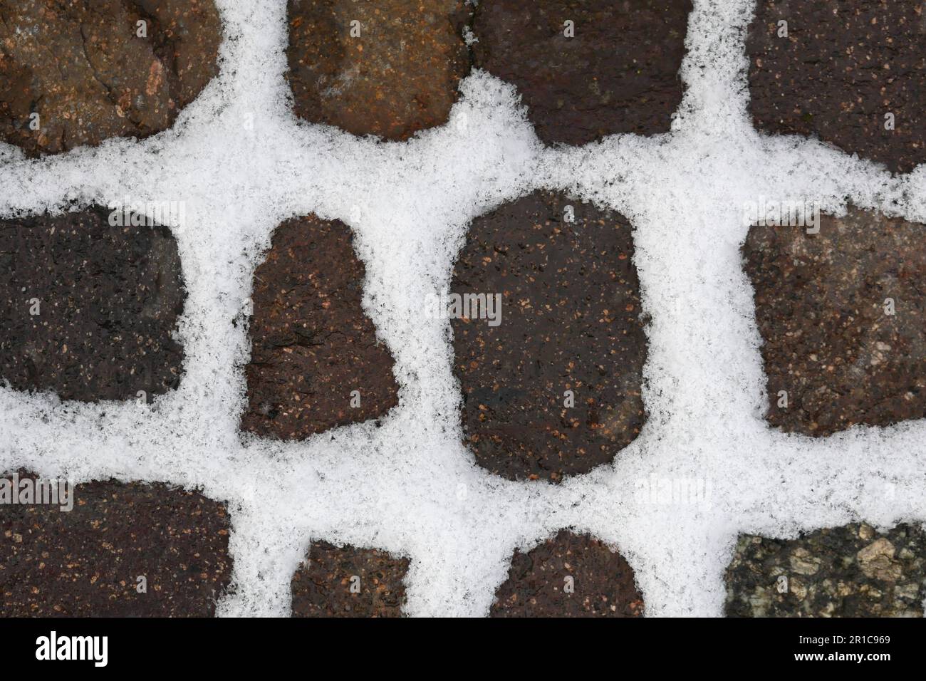 Schnee füllt alle Steinspalten eines Gehwegs Stockfoto