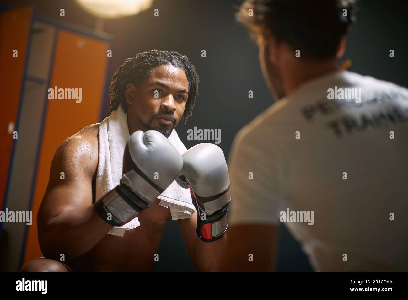 Junger schwitzender Boxspieler, der nach dem Training mit dem Trainer sitzt. Ich fühle mich mächtig. Sport, Lifestyle-Konzept. Stockfoto