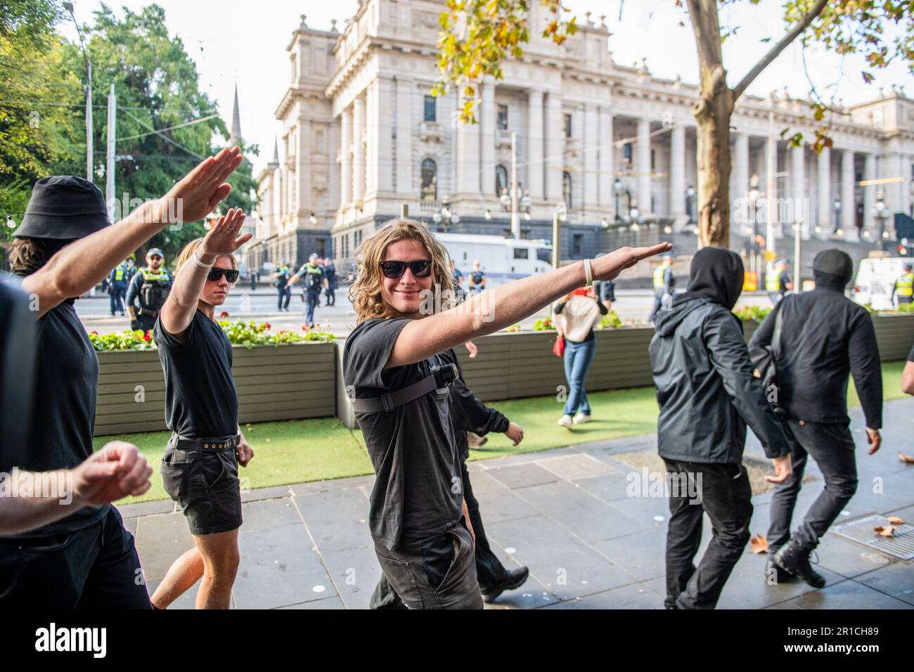 Neonazis-Demonstranten salutieren, wie ihnen befohlen wird, das Gebiet während der Demonstration zu verlassen. Ein Tag politischer Spannungen und Zusammenstöße entfaltete sich in Melbourne als rechtsextreme Gruppe einer Neonazi-Gruppe, die eine Anti-Einwanderungs-Kundgebung im staatsparlament veranstaltete, und traf auf heftigen Widerstand von linksgerichteten antifaschistischen Gegenprotestierenden. Die Aufruhr-Polizei wurde eingesetzt, als es zwischen den beiden Gruppen zu Schlägereien kam, mit Pfefferspray und Pferden, um die Menge zu kontrollieren. Protestsignale, die Inklusivität, Vielfalt und soziale Gerechtigkeit fordern, wurden in einer Demonstration der Einheit gegen Hassreden und Diskriminierung hoch gehalten. Die Überschneidungen sind heller Stockfoto