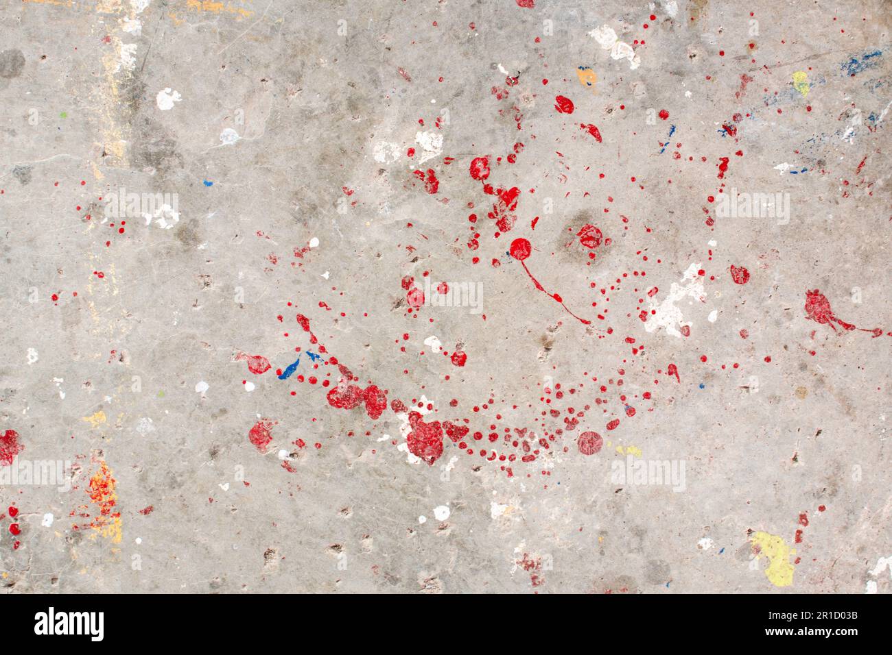 Der Boden ist mit mehreren Tropfen in verschiedenen Farben befleckt. Tropfende Farbe auf dem Betonboden wunderschöne Kunst. Tröpfchen mit roten, schwarzen und weißen Flecken Stockfoto