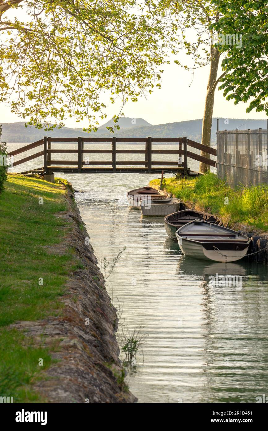 Schöne Brücke mit einem kleinen Kanal in Balatonbolar und Fischerbooten neben dem Balaton. Stockfoto