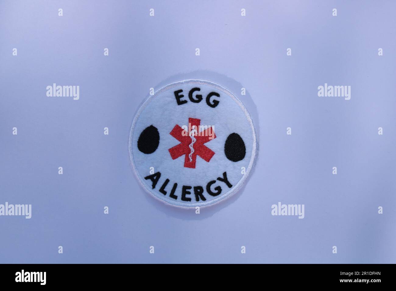 Ei-Allergie-Alarm, aufgenäht auf einem einfarbigen Hintergrund. Lancashire, Vereinigtes Königreich, 13-05-2023 Stockfoto