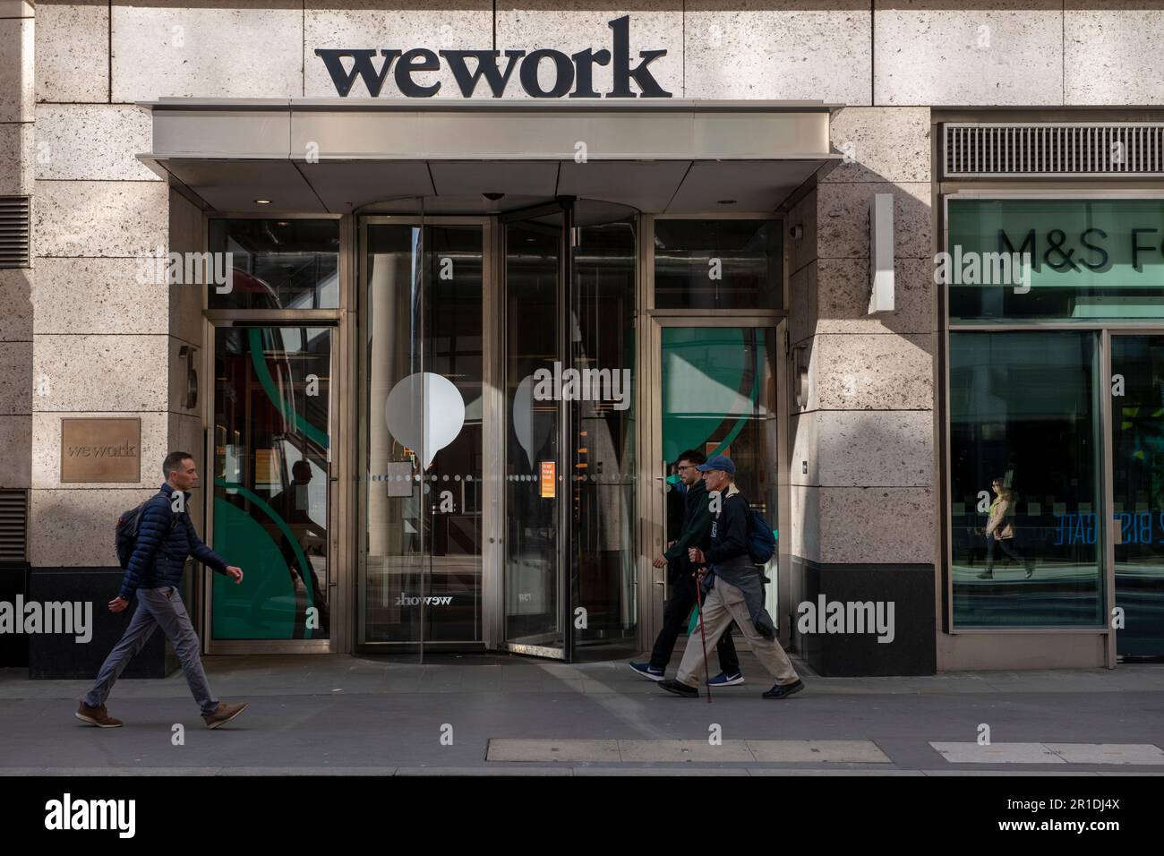 Fußgänger, der an einem WeWork Coworking Space vorbeigeht, 15 Bishopsgate, City of London, Großbritannien. 7. April 2023 Stockfoto