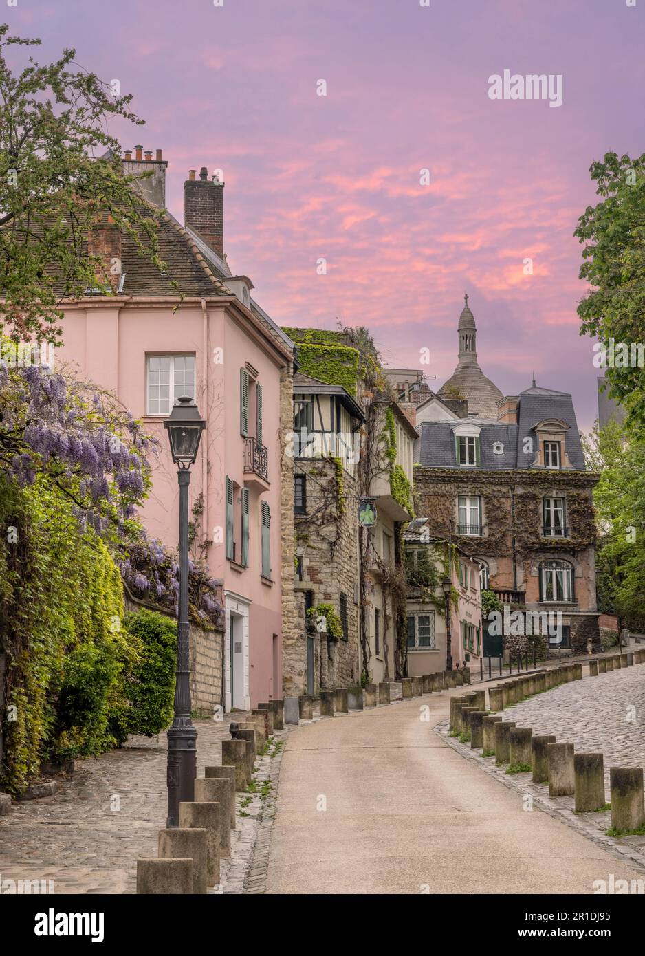 Paris, Mon Martre und Sacre Coeur blicken auf eine alte Kopfsteinpflasterstraße in Richtung Kirche. Stockfoto