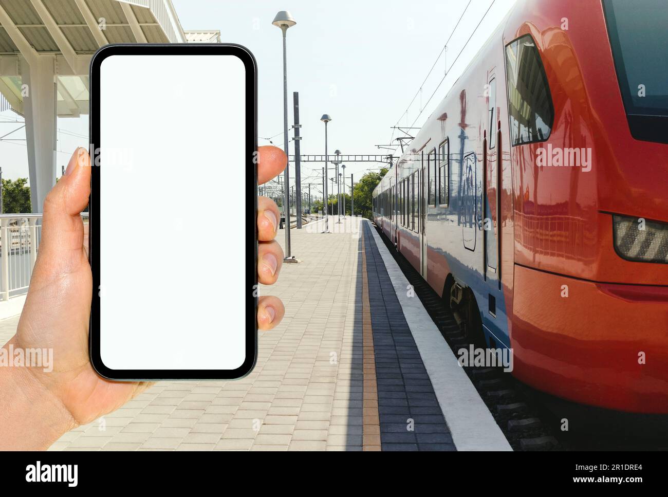 Telefon mit leerem Bildschirm im Hintergrund des Bahnhofs und Bahnhofs. Stockfoto