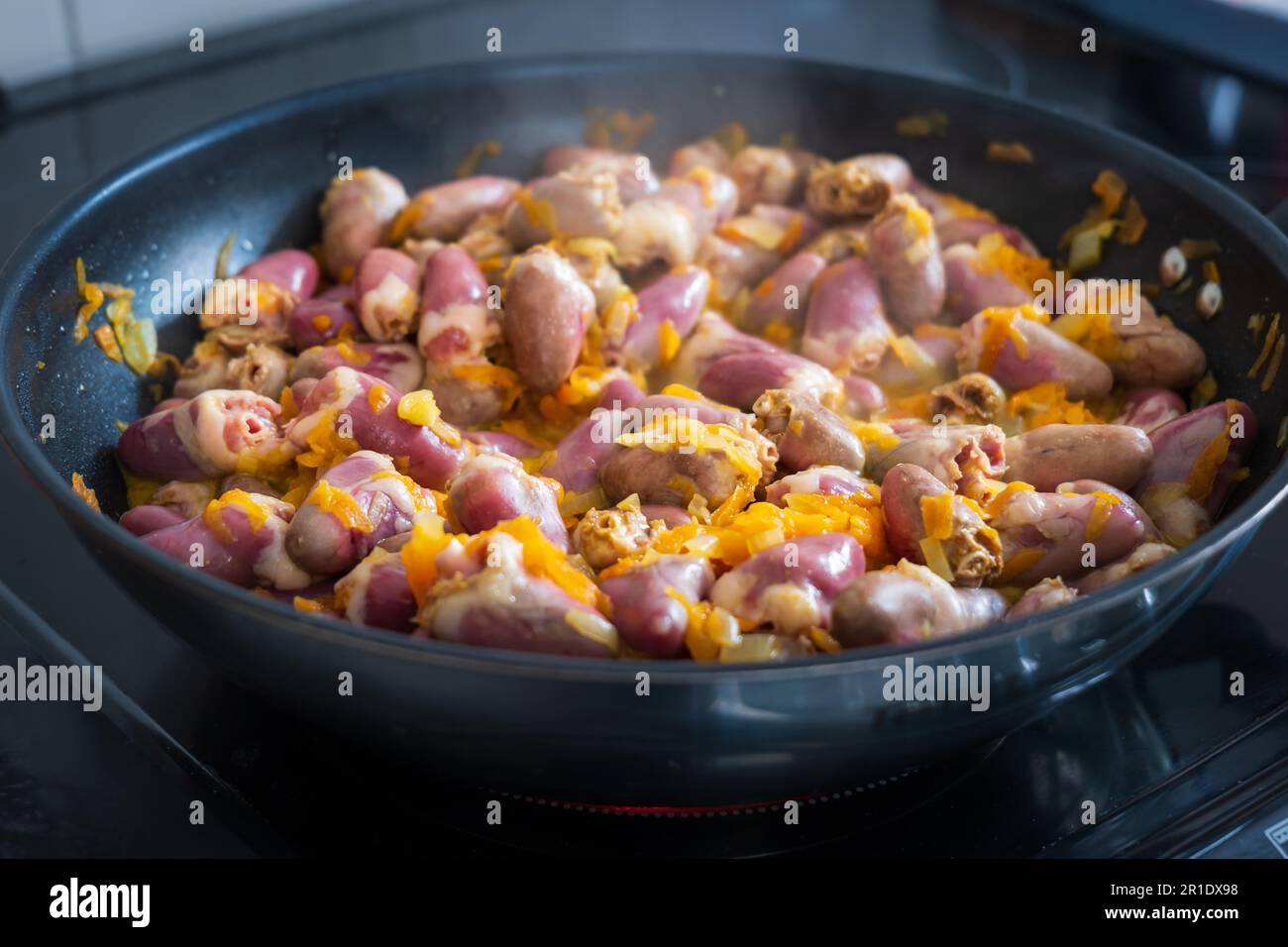 Hühnerherzen mit Gemüse in der Pfanne. Stockfoto