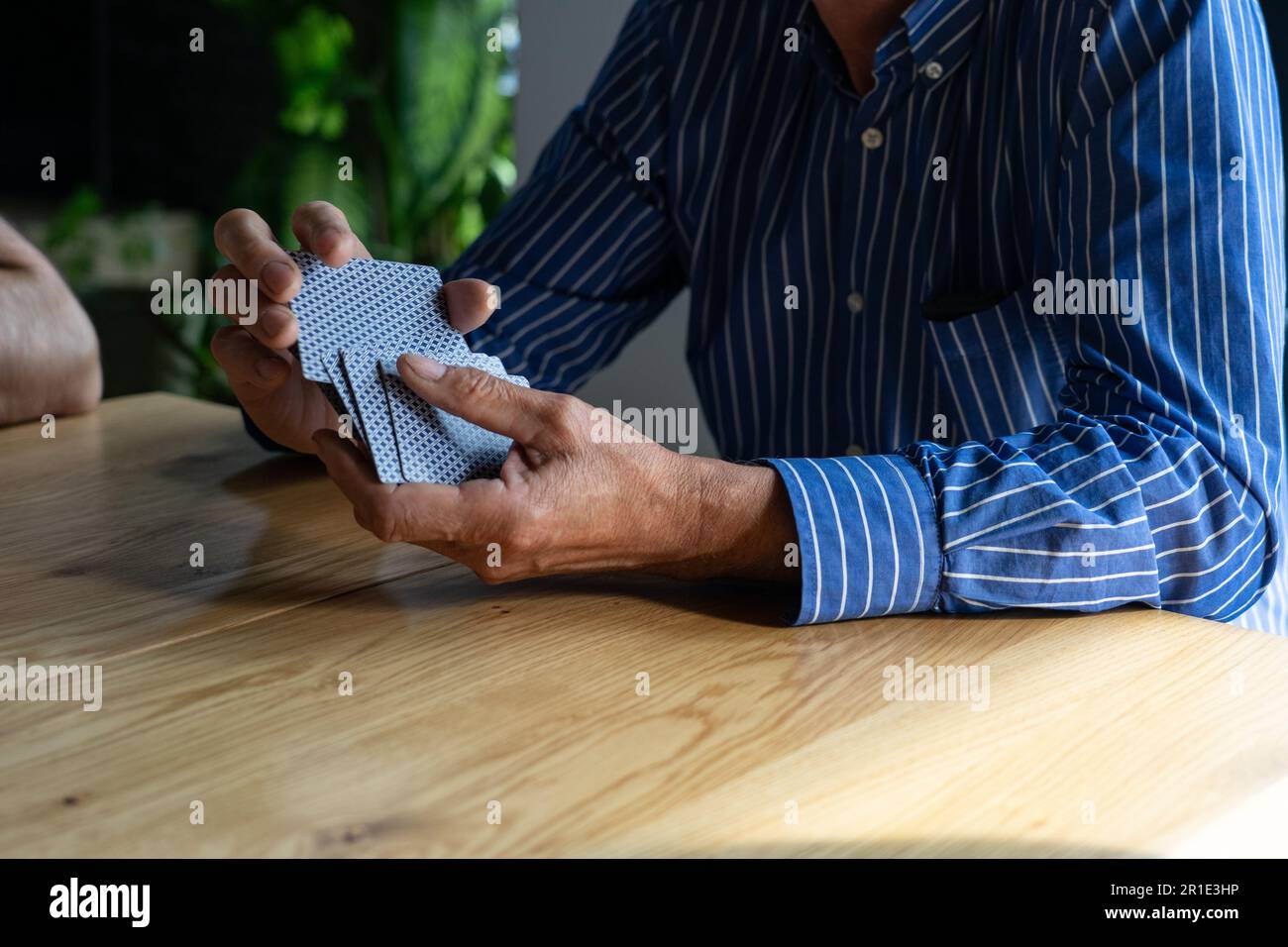 Mann mischt Karten beim Spielen mit Freunden. Stockfoto
