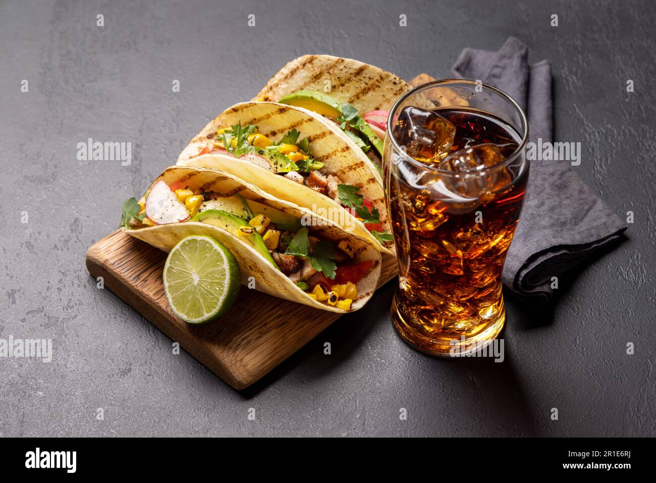 Mexikanische Küche mit Tacos mit Fleisch und gegrilltem Gemüse und ein Glas Cola mit Eis Stockfoto