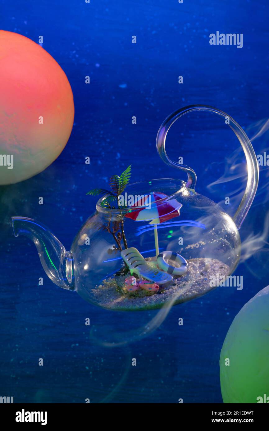 Transparenter Glas-Teekanne mit Sand, Sonnenbank, Sonnenschirm, Flip-Flops, Rettungsschwimmer im Inneren schwebt im Raum zwischen roten und grünen Planeten mit dampfgenarbtem vertikalem Foto, blauem Hintergrund, Fokus auf Stuhl. Hochwertiges Foto Stockfoto