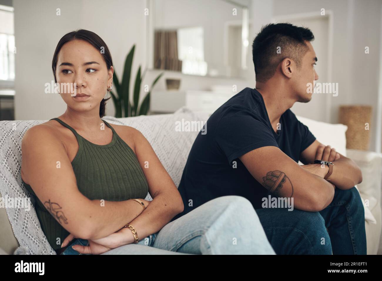Sie sitzen still. Ein junges Paar, das sich nach einem Streit zu Hause ignoriert. Stockfoto