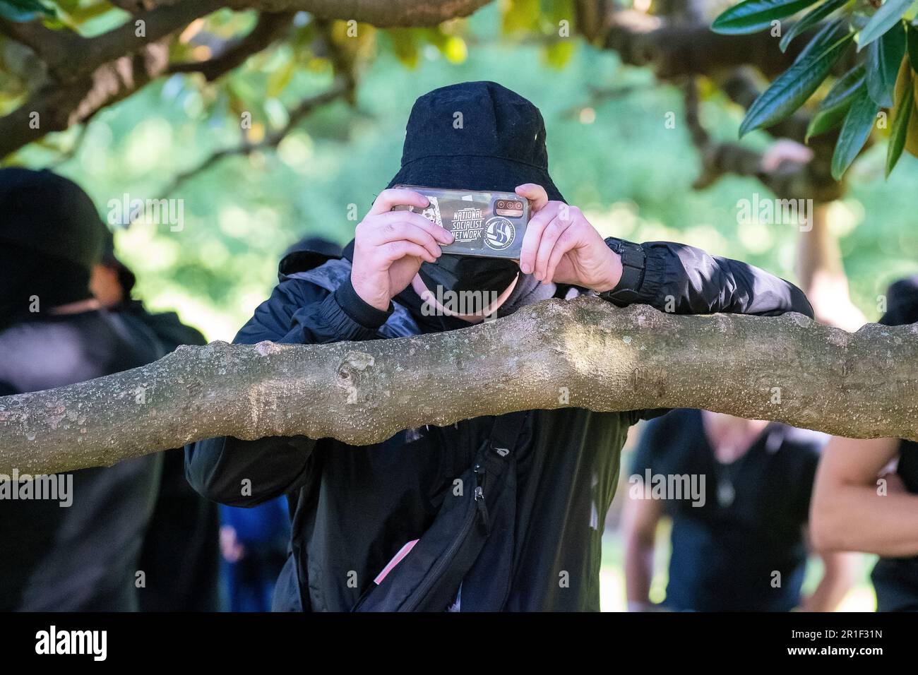 Melbourne, Australien, 13. Mai 2023. Ein "Neonazi", der auf seinem Handy Antifaschistenaufkleber zu haben scheint, macht Fotos von den Medien während einer hitzigen politischen Kundgebung gegen Rassismus, während rechtsextreme Neonazis eine Demonstration im staatsparlament abhielten, die am 13. Mai 2023 in Melbourne, Australien, zu Zusammenstößen und Abrissen führte. Kredit: Michael Currie/Speed Media/Alamy Live News Stockfoto