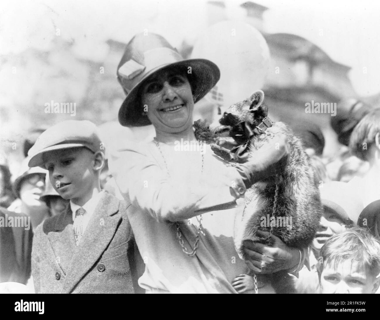 Archivfoto: Mrs. Coolidge stellt ihren Waschbär [Rebecca] vor den Menschenmengen von Kindern aus, die sich zu Ostern zum Eierrollen versammelt haben. 1927 Stockfoto