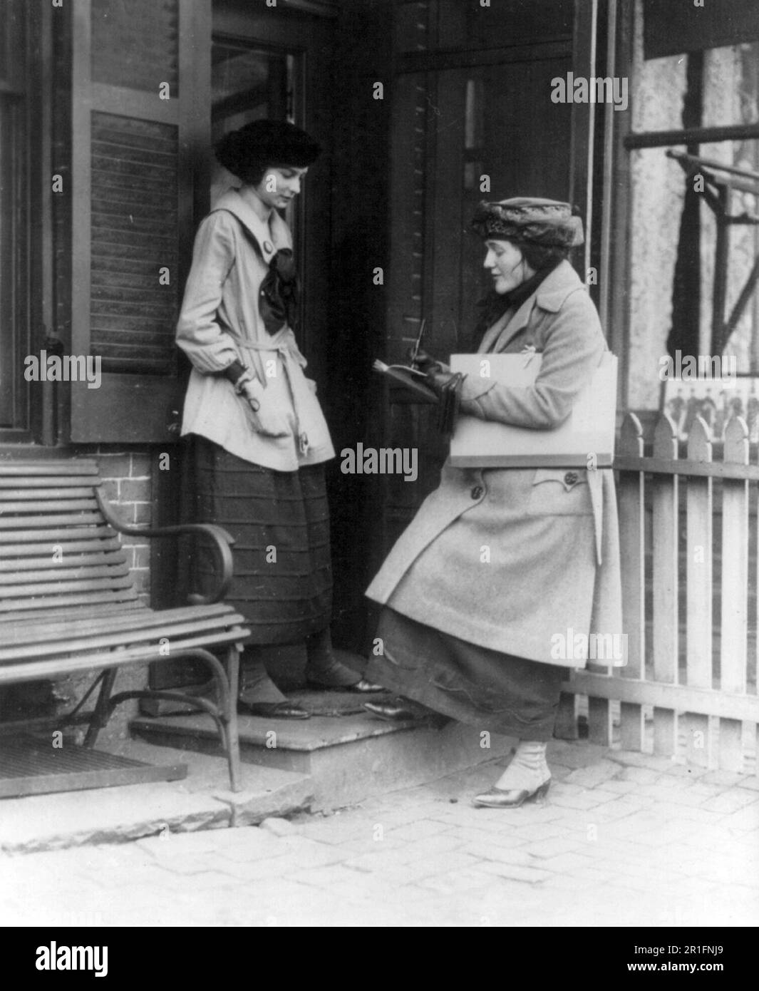 Archivfoto: Frau nimmt eine Volkszählung einer anderen Frau vor Haus ca. 1909-1932 Stockfoto