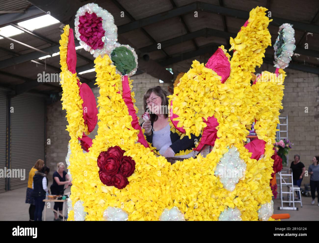 Spalding, Großbritannien. 11. Mai 2023. Lilian Hitchen hat damit begonnen, Tulpenköpfe auf dem Floß der Blumenkönigin an die Krone zu „kleben“, bereit für das Spalding Flower Festival, das morgen (13. Mai) beginnt. Die Parade wurde von Stephen Timewell wiederbelebt, nachdem sie das letzte Mal im Jahr 2013 stattfand. Über eine Million Tulpenköpfe werden zur Dekoration von Schwimmwagen verwendet, die am 13. Mai 2023 durch die Stadt Spalding in Lincolnshire fahren werden. Kredit: Paul Marriott/Alamy Live News Stockfoto