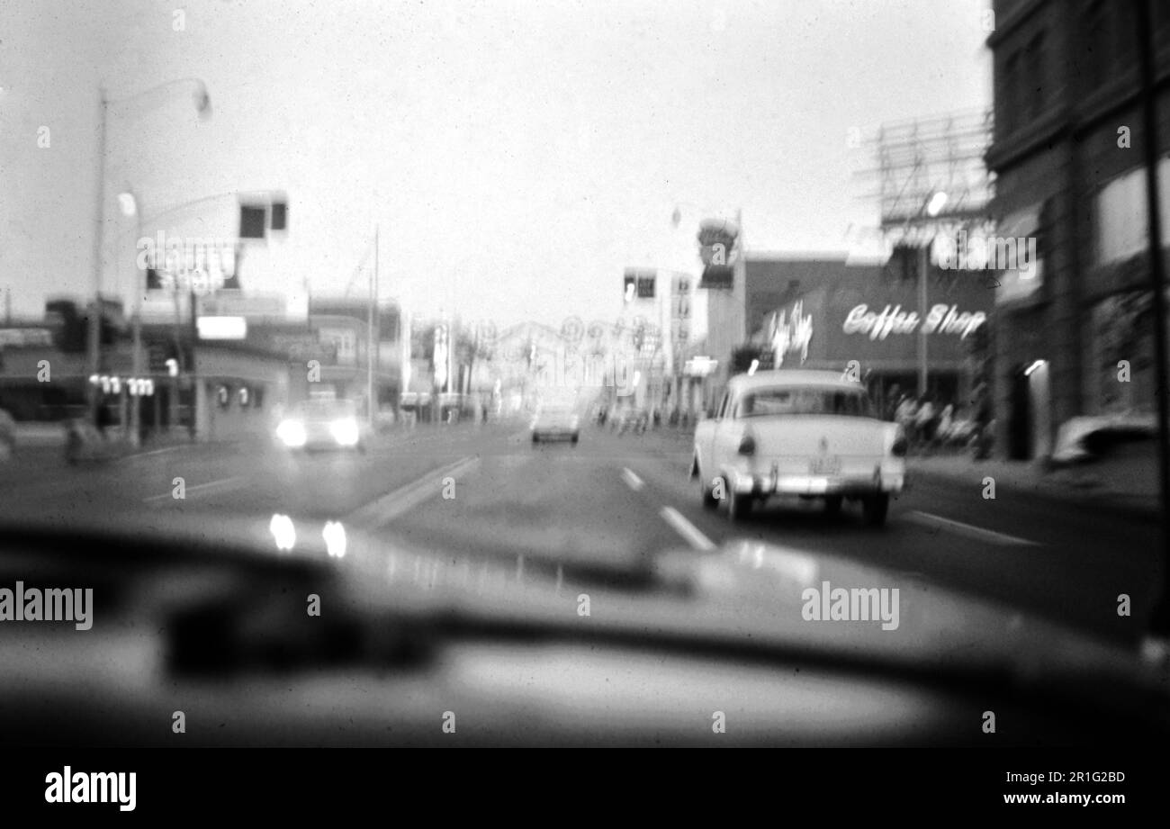 Filmen Sie Noir wie ein Schwarzweißfoto des Verkehrs in einer Stadt in der Dämmerung. 1963 Stockfoto