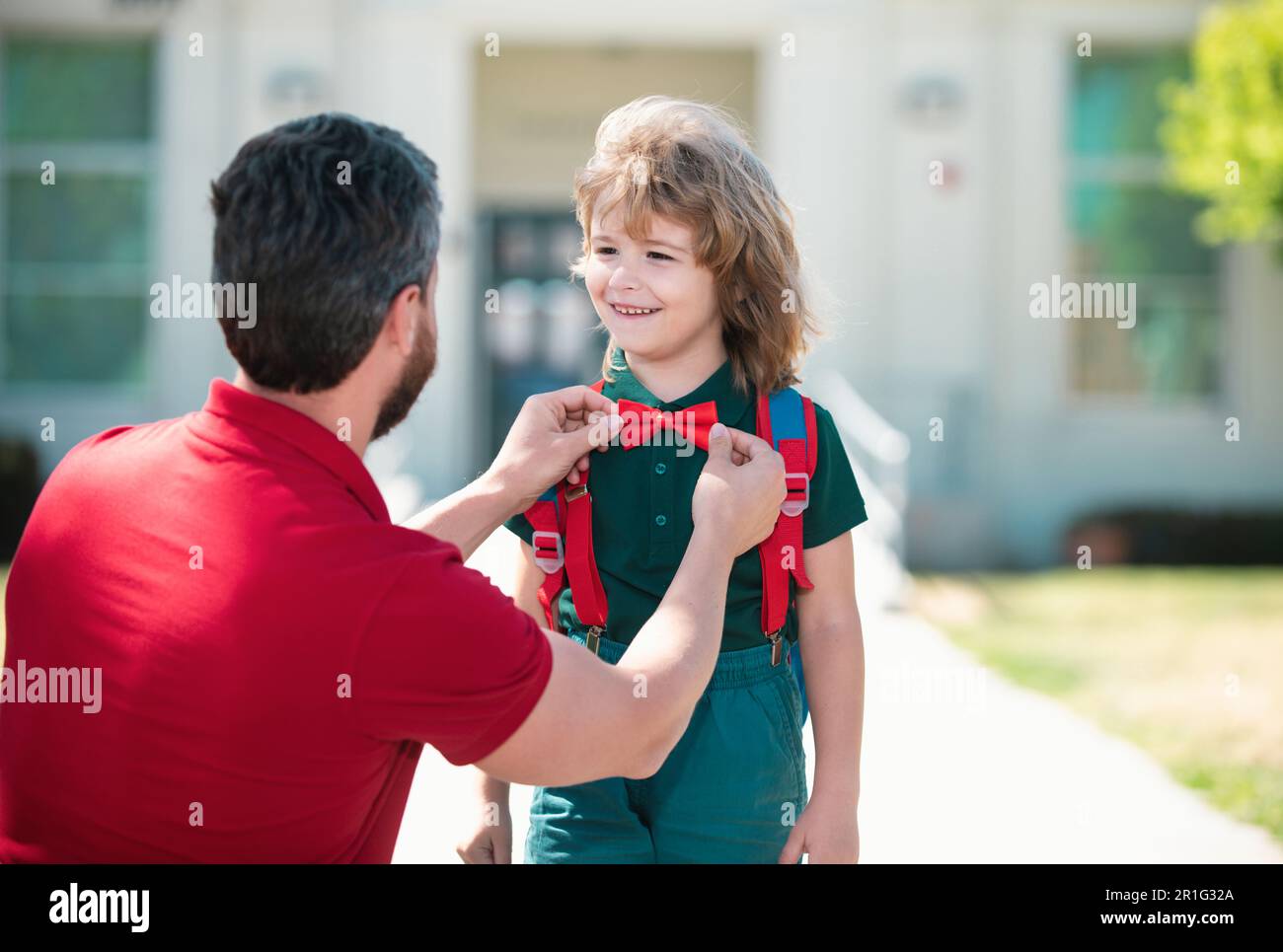 Vater sagt Auf Wiedersehen seinem kleinen Sohn in der Nähe der Schule. Kindererziehung. Erster Schultag. Stockfoto
