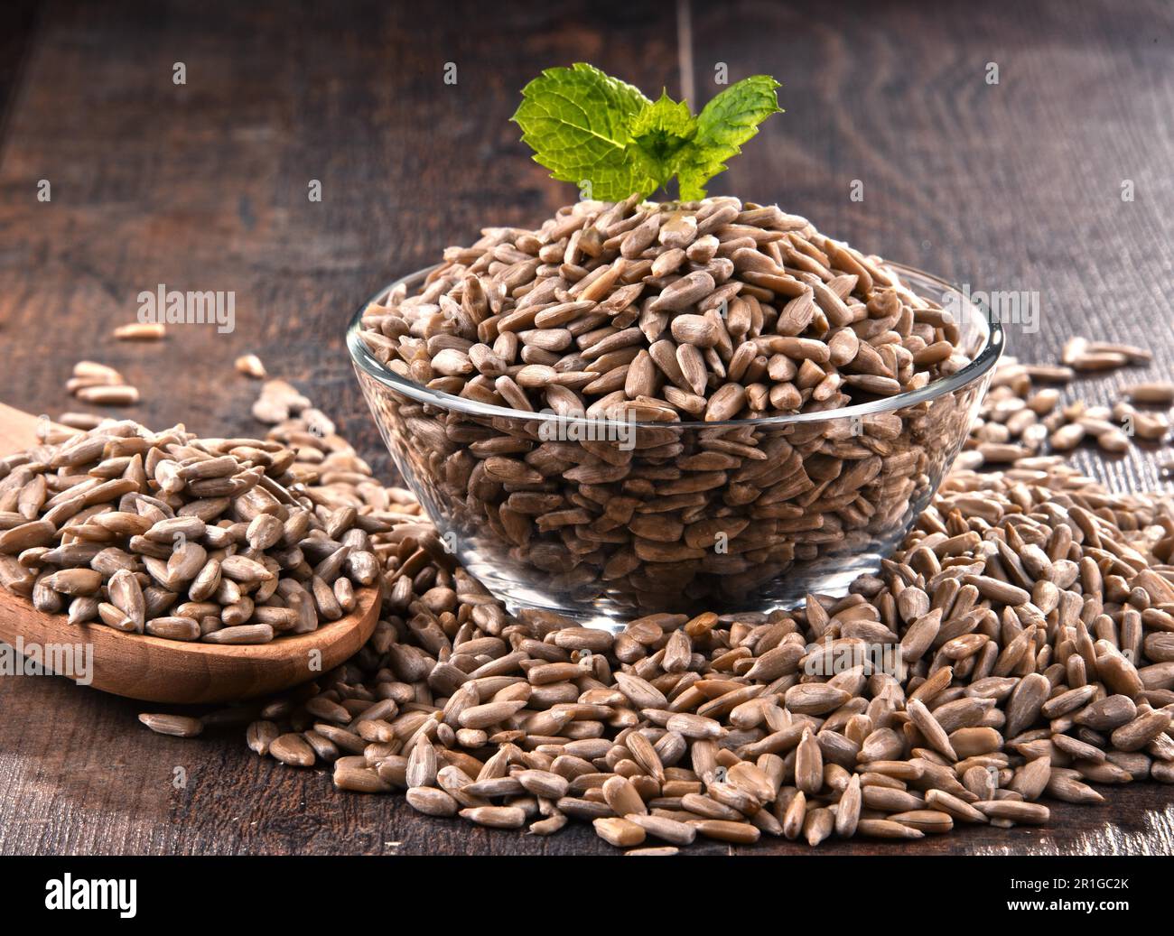 Komposition mit Schale geschält Sonnenblumenkerne auf hölzernen Tisch Stockfoto