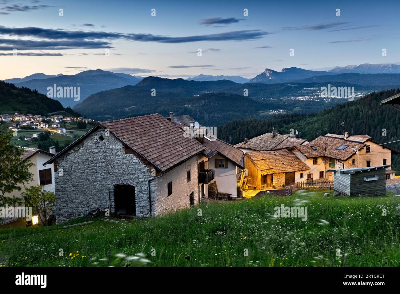 Abenddämmerung im alpinen Dorf Perpruneri. Im Hintergrund das Lavarone-Plateau. Folgaria, Alpe Cimbra, Trentino, Italien. Stockfoto