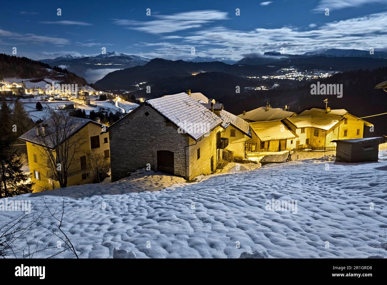 Winternacht im Bergdorf Perpruneri. Im Hintergrund das Lavarone-Plateau. Folgaria, Alpe Cimbra, Trentino, Italien. Stockfoto
