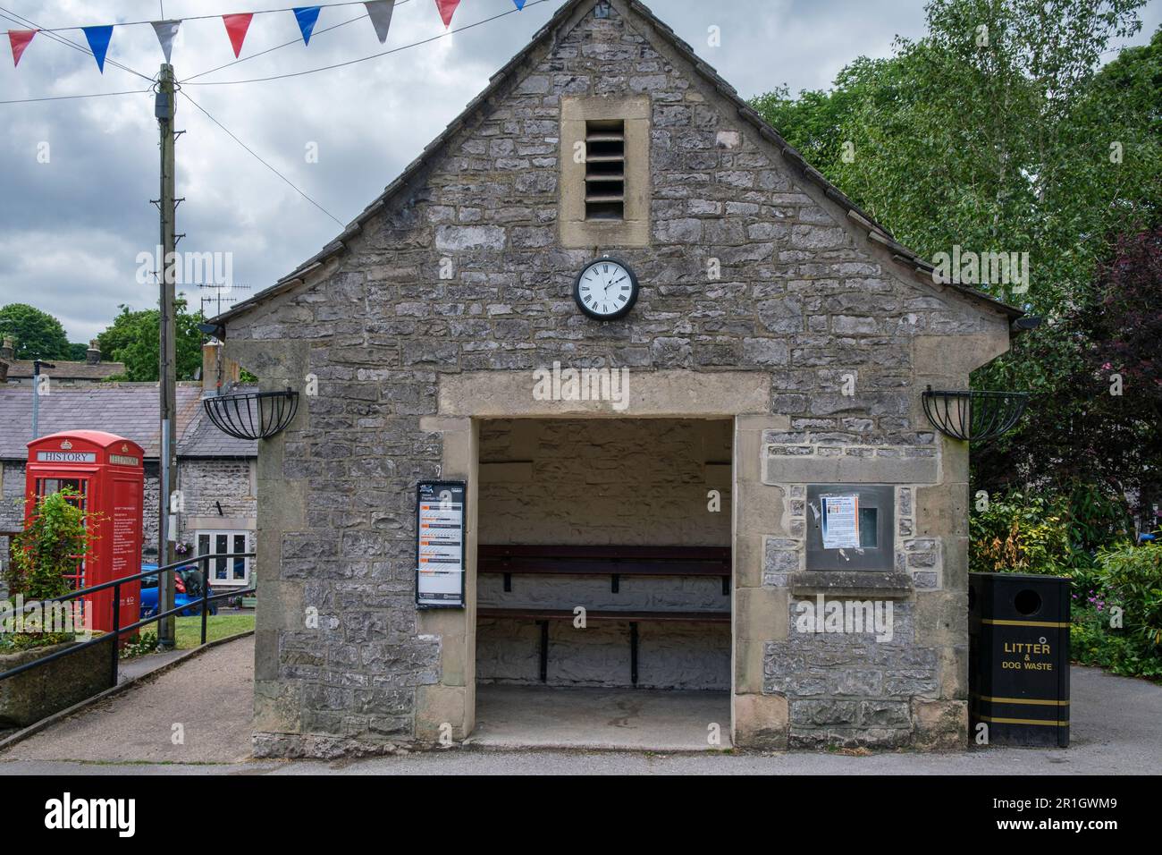 Bushaltestelle neben einer Telefonzelle, die im Dorf Tideswell, Peak District National Park, Derbyshire als „Geschichtsbox“ umfunktioniert wurde Stockfoto