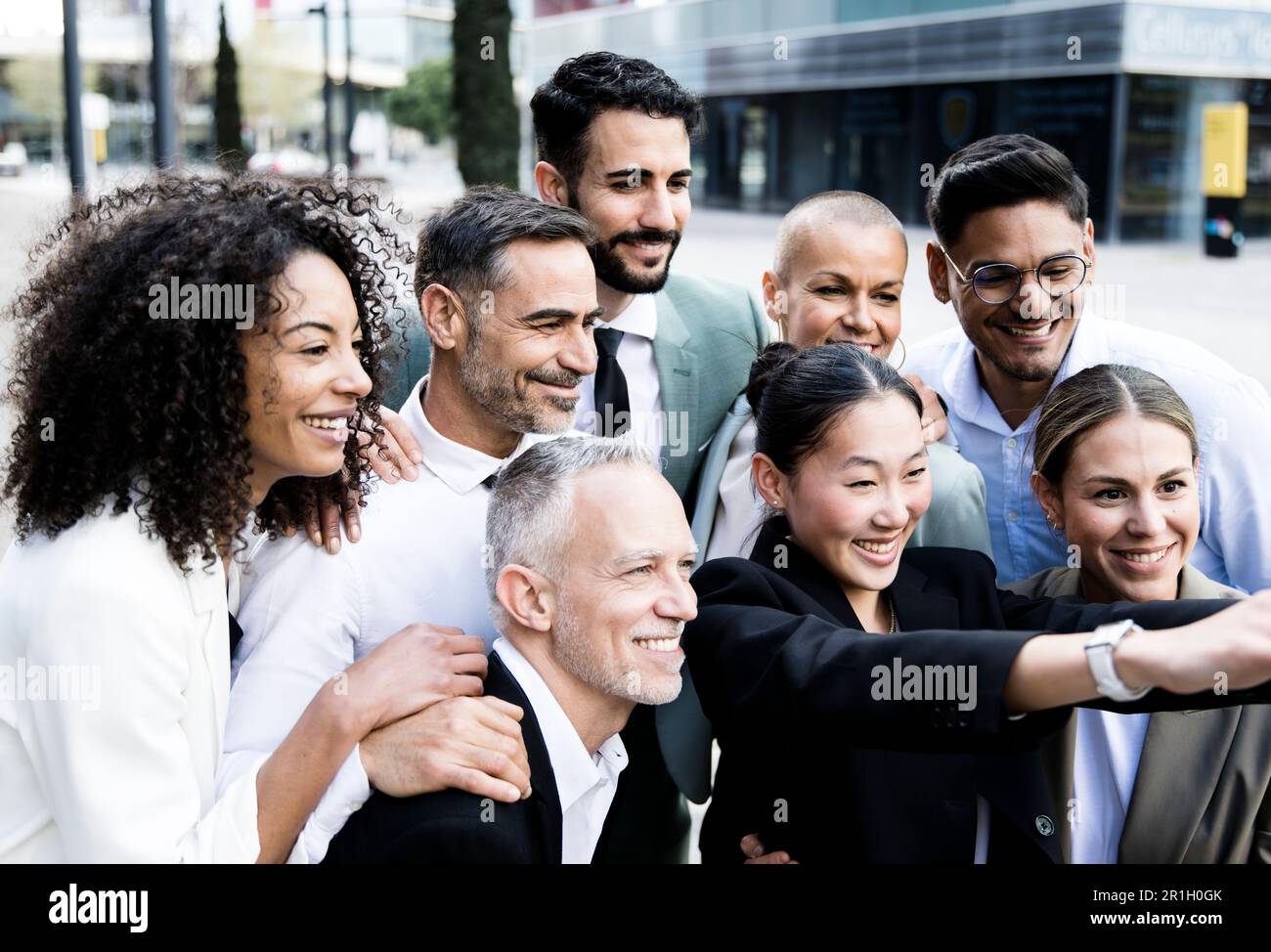 Eine Gruppe erfolgreicher Geschäftsleute, die ein Selfie vor der Tür machen. Vielseitige Bürokollegen, die ein Bild machen, lächeln und sich anfreunden Stockfoto