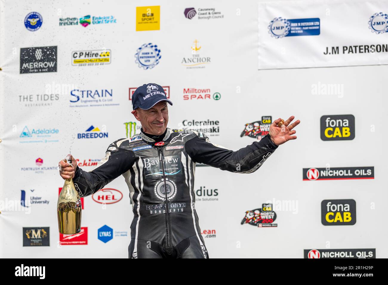 Portstewart, Großbritannien. 13. Mai 2023. Richard Cooper auf dem Podium, nachdem er das J M Paterson SuperTwin Klassenrennen bei der Northwest 200 gewann. Positionen 1. Richard Cooper. 2. Jeremy McWilliams. 3. Adam McLean Credit: Bonzo/Alamy Live News Stockfoto