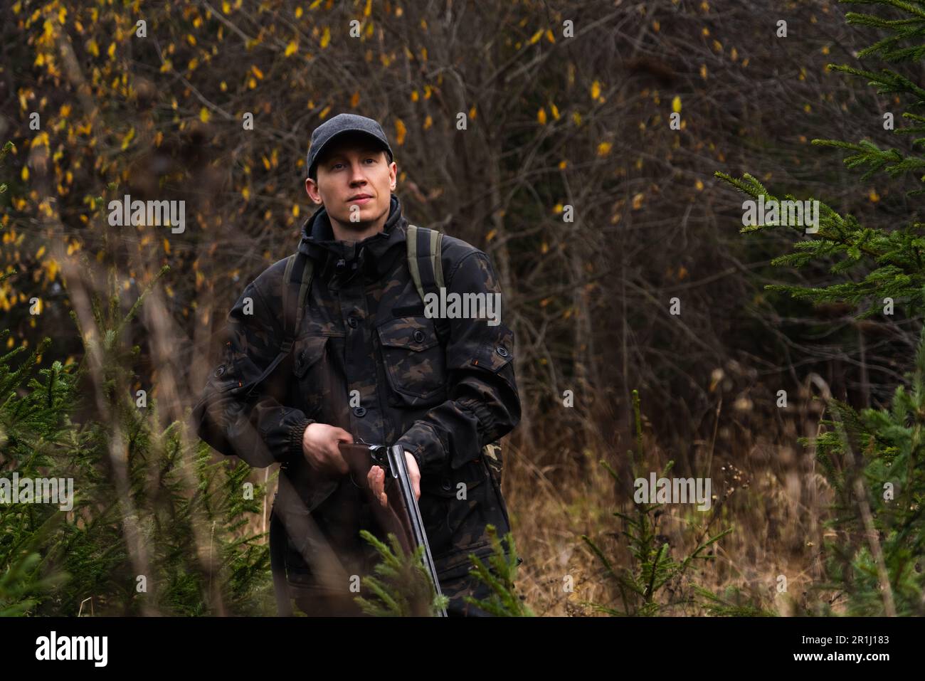 Jäger mit einer Waffe und einem Rucksack im Wald. Hochwertiges Foto Stockfoto