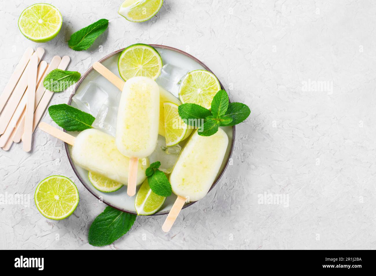 Erfrischende Limetteneis, brasilianische Limonade Ice Lolly mit frischem Limone und Minze auf hellem Hintergrund, gesundes Dessert Stockfoto