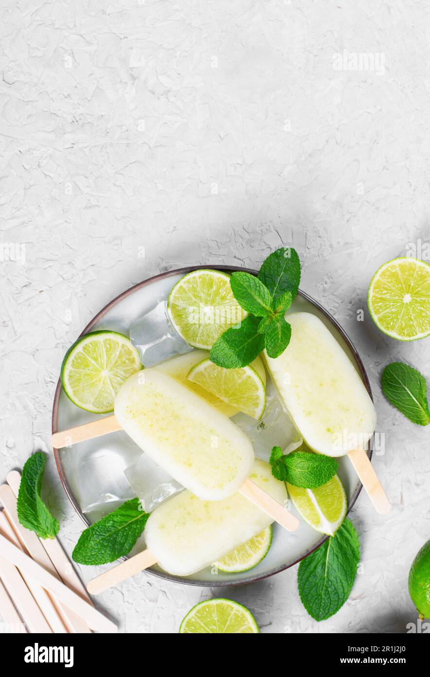 Erfrischende Limetteneis, brasilianische Limonade Ice Lolly mit frischem Limone und Minze auf hellem Hintergrund, gesundes Dessert Stockfoto