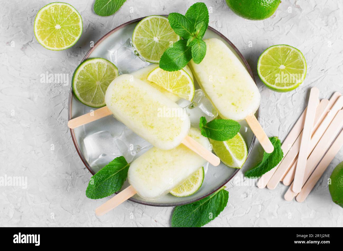 Erfrischende Limetteneis, brasilianische Limonade Ice Lolly mit frischem Limone und Minze auf hellem Hintergrund, gesundes Dessert Stockfoto