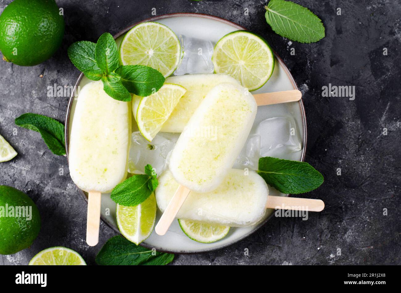 Erfrischendes Limetteneis, brasilianisches Limonadeneis Lolly mit frischer Limette und Mint auf dunklem Hintergrund, gesundes Dessert Stockfoto