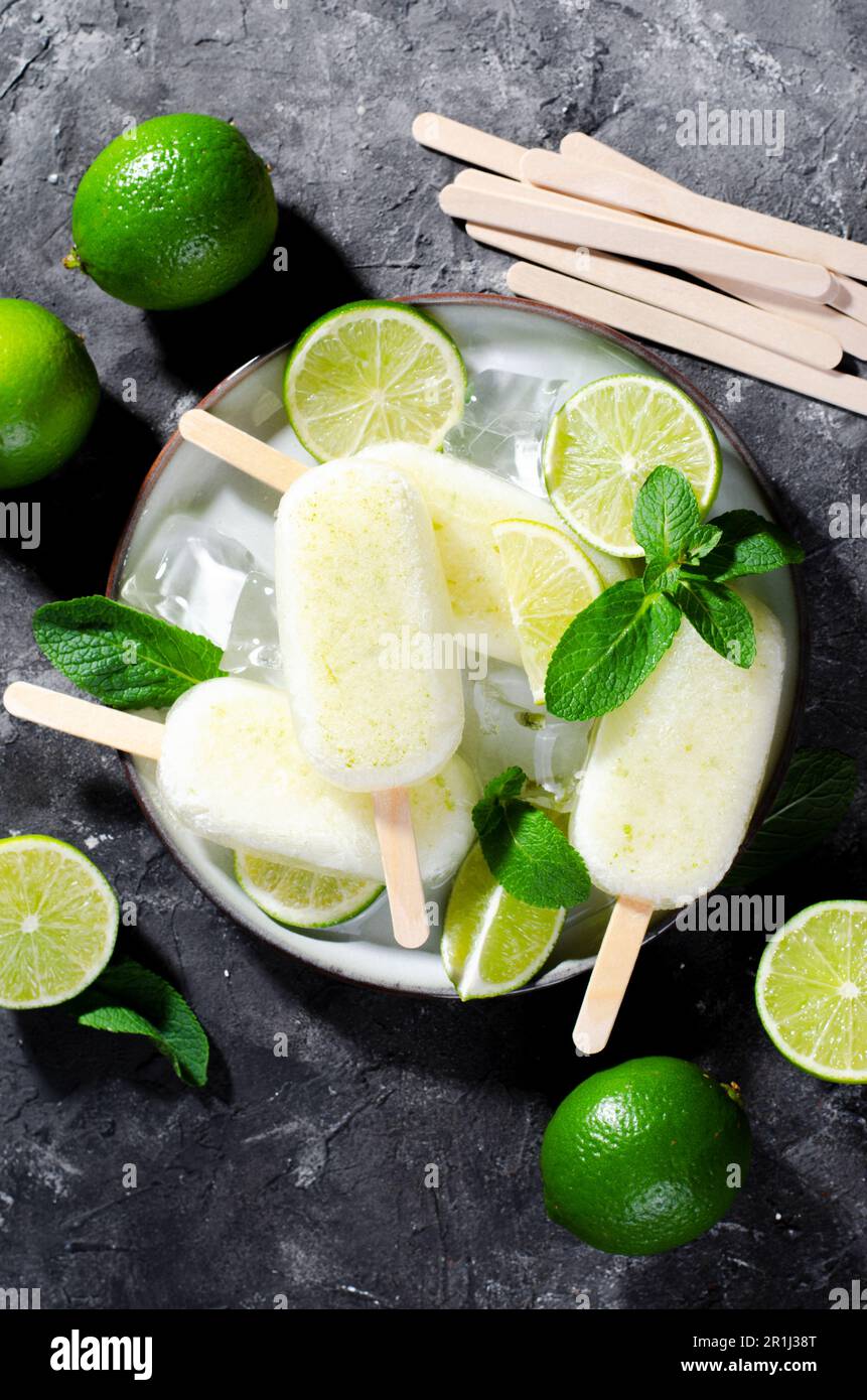 Erfrischendes Limetteneis, brasilianisches Limonadeneis Lolly mit frischer Limette und Mint auf dunklem Hintergrund, gesundes Dessert Stockfoto