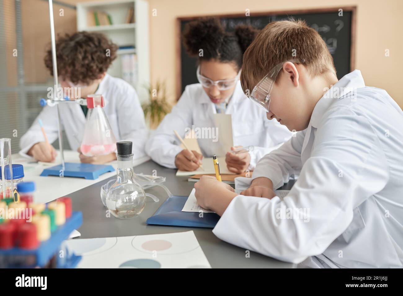 Seitenansicht des Schuljungen im Wissenschaftsunterricht mit Kindergruppe, Kopierraum Stockfoto