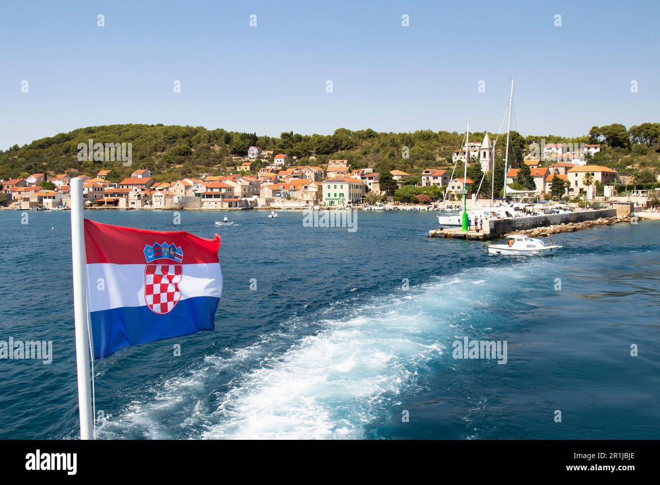 Prvic Luka, Kroatien - 22. Juli 2022: Kroatische Flagge auf einer Fähre, die die kleine Stadt Luka auf der Insel Prvic verlässt Stockfoto