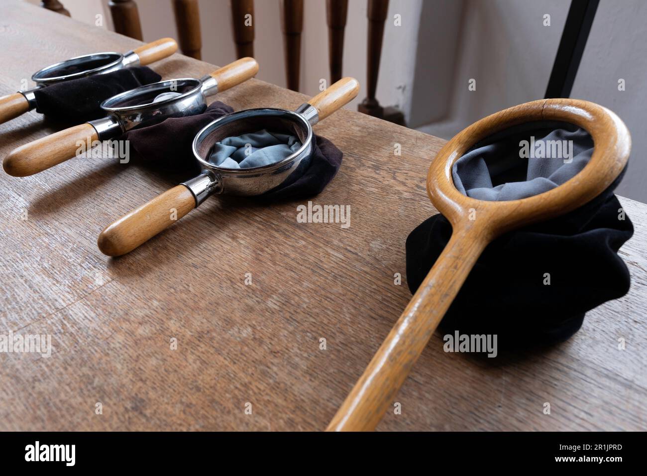 Schwarze Sammelbeutel liegen auf einem Holztisch in einer Kirche, bereit, Geld für gute Zwecke nach dem Gottesdienst zu sammeln Stockfoto