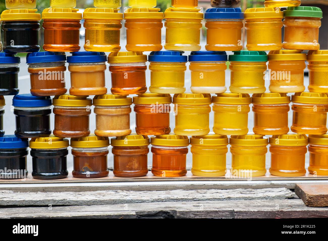 Gläser mit verschiedenen Arten von frischem Bio-Honig im Freien auf dem Bauernmarkt. Gesundes Essen Stockfoto
