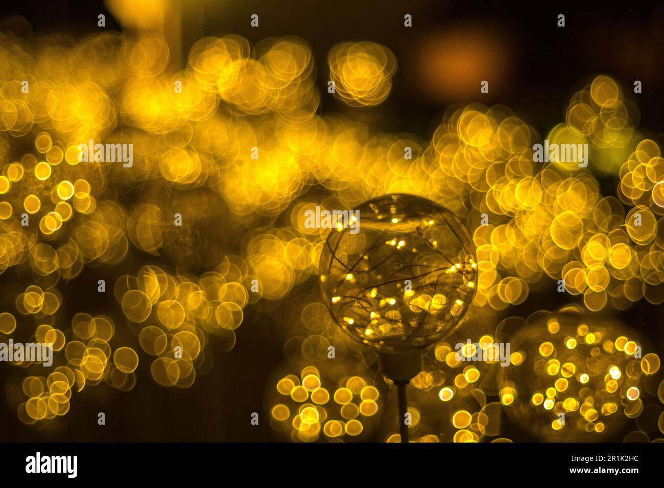 Goldene Bokeh Lichter Hintergrund mit glühender Feenlicht Glasbirne Stockfoto