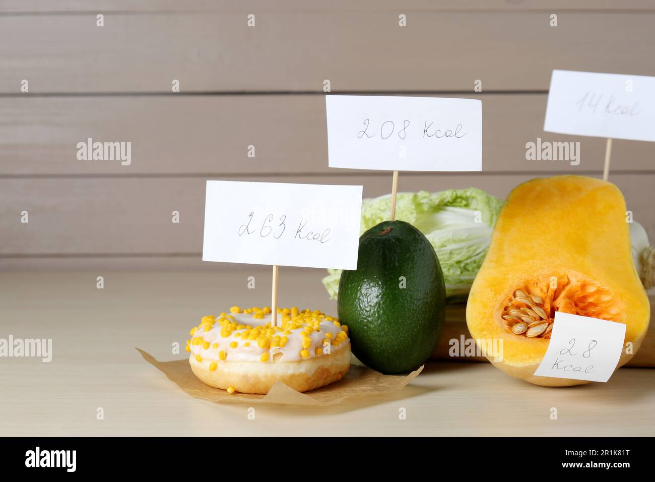 Lebensmittel mit Heizwertanhängern auf Holztisch, Platz für Text. Gewichtsverlust-Konzept Stockfoto