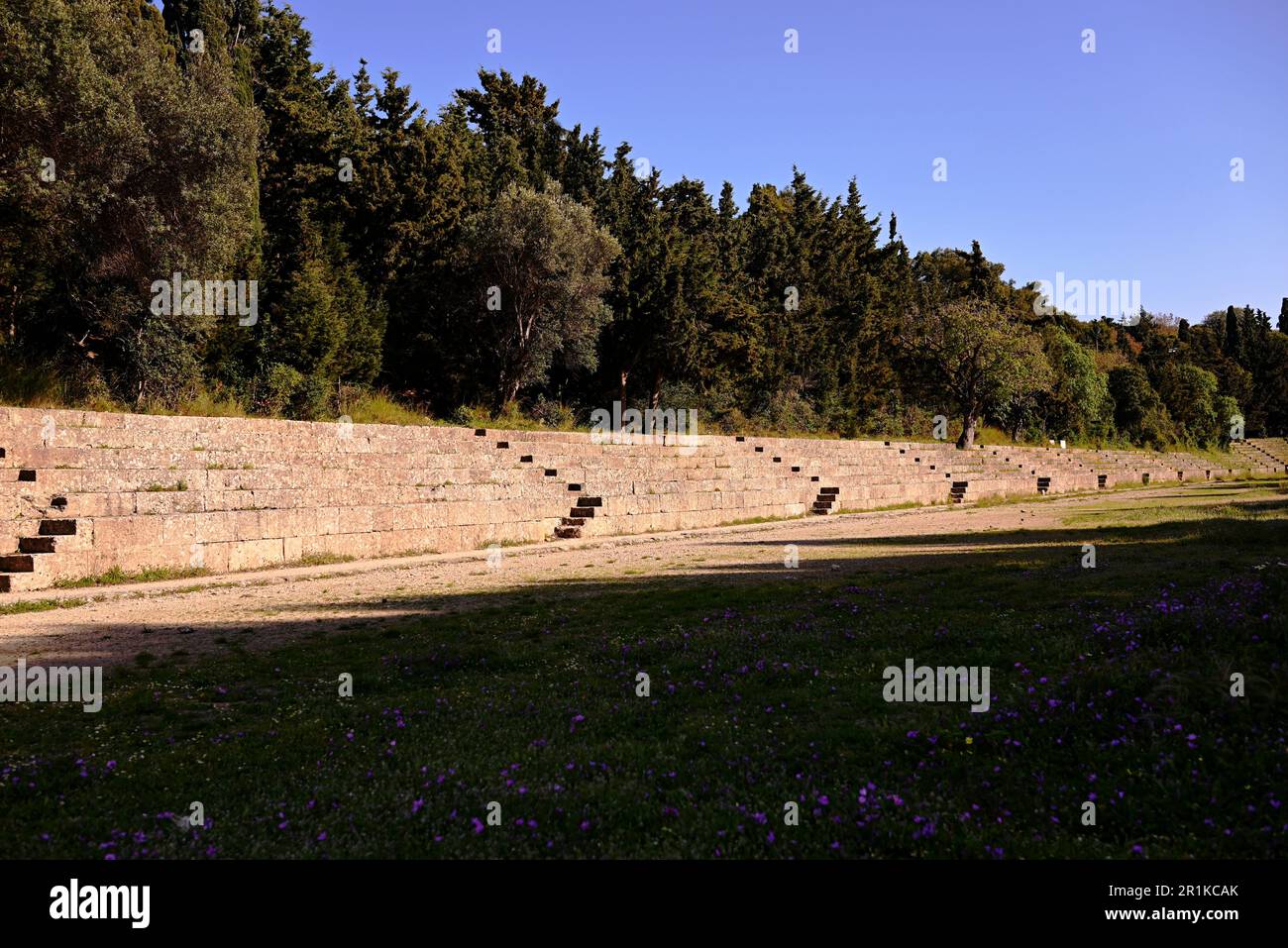 Ein antikes griechisches Stadion mit Stein steht für den Fünfkampf alter Athleten. Das Stadion ist von Thujas und Lorbeersträuchern umgeben. Stockfoto