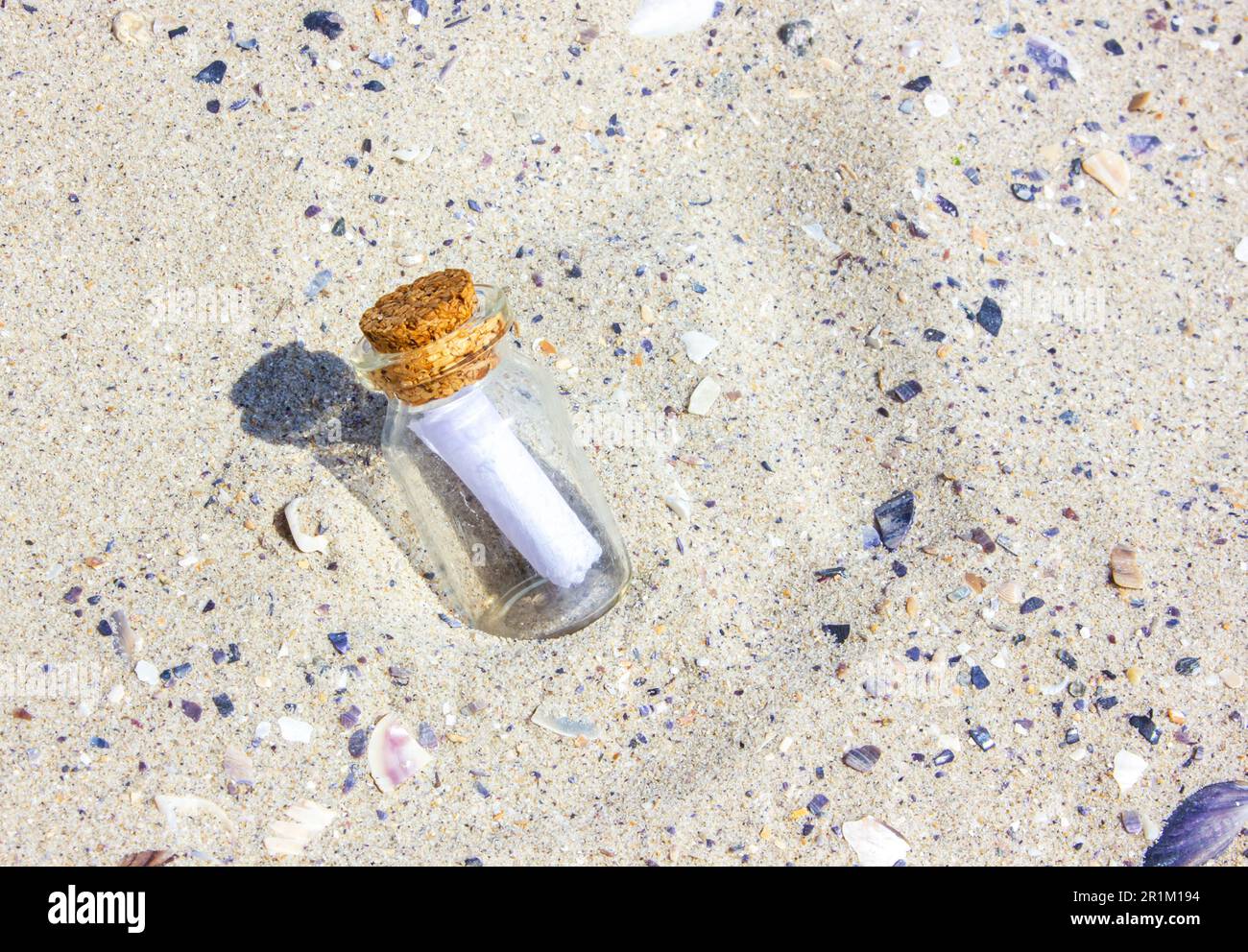 Eine Nachricht in einer Korkflasche am Strand. Die Flasche im Sand. Die Flasche am Sandstrand. Sonniger Tag. Stockfoto