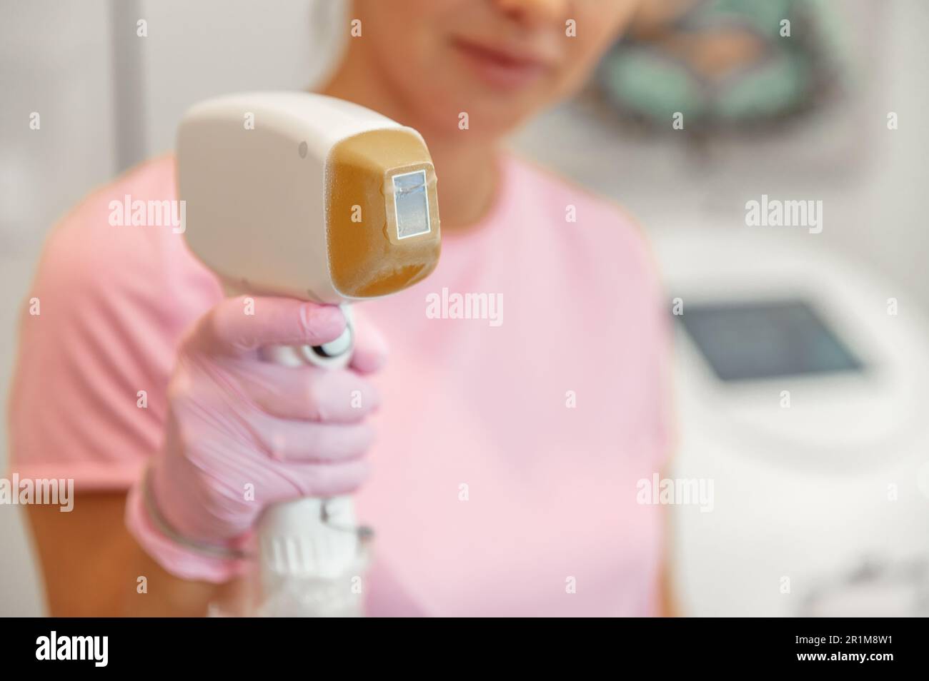 Nahaufnahme eines Lasergeräts in weiblichen Händen zur Entfernung unerwünschter Körperhaare in einem Schönheitssalon Stockfoto