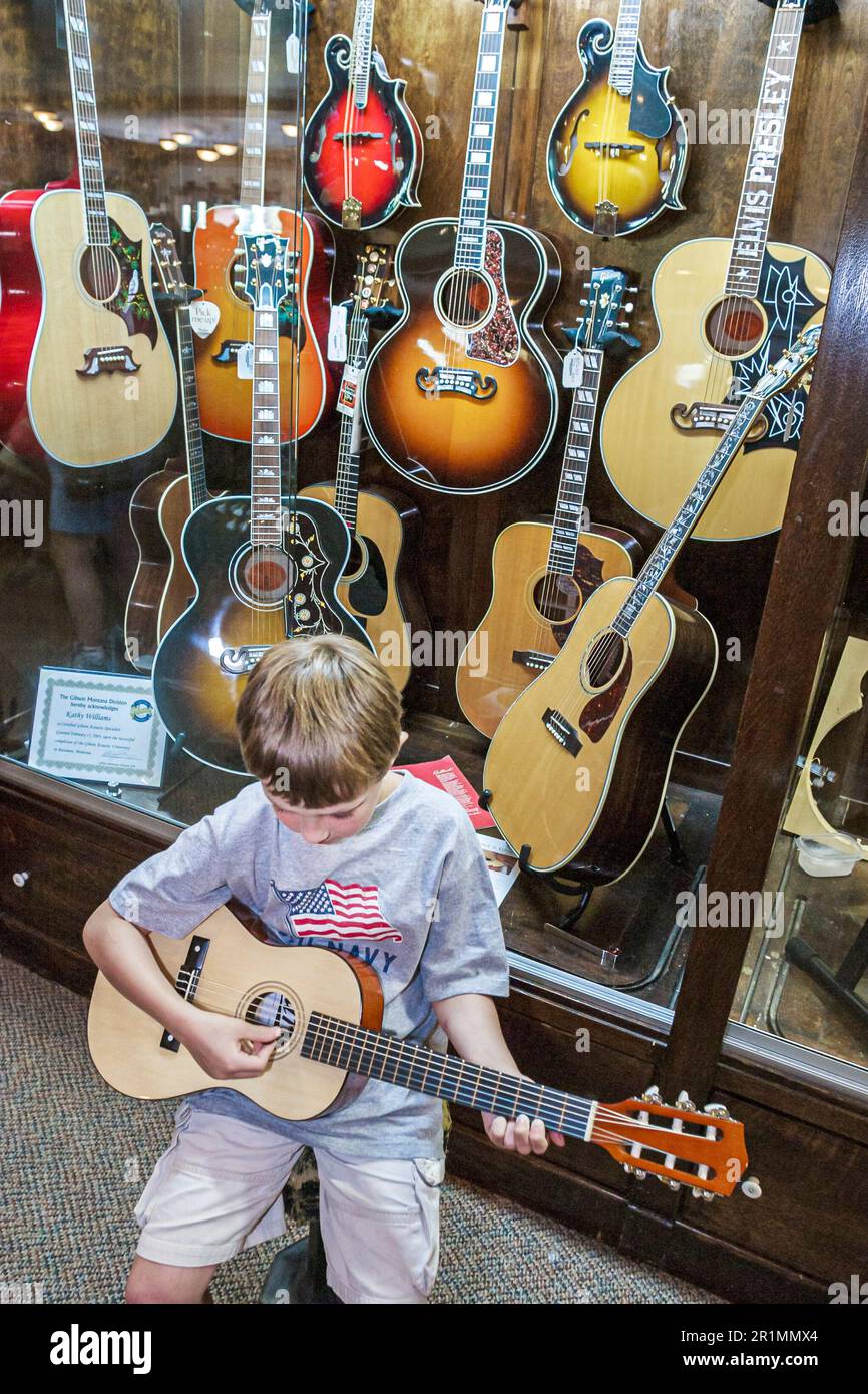 Sevierville Tennessee, Music Outlet Store Geschäft Musikinstrumente Verkauf Einkaufen, innen Junge versuchen, Kindergitarre spielen, Gitarren-Display, Stockfoto