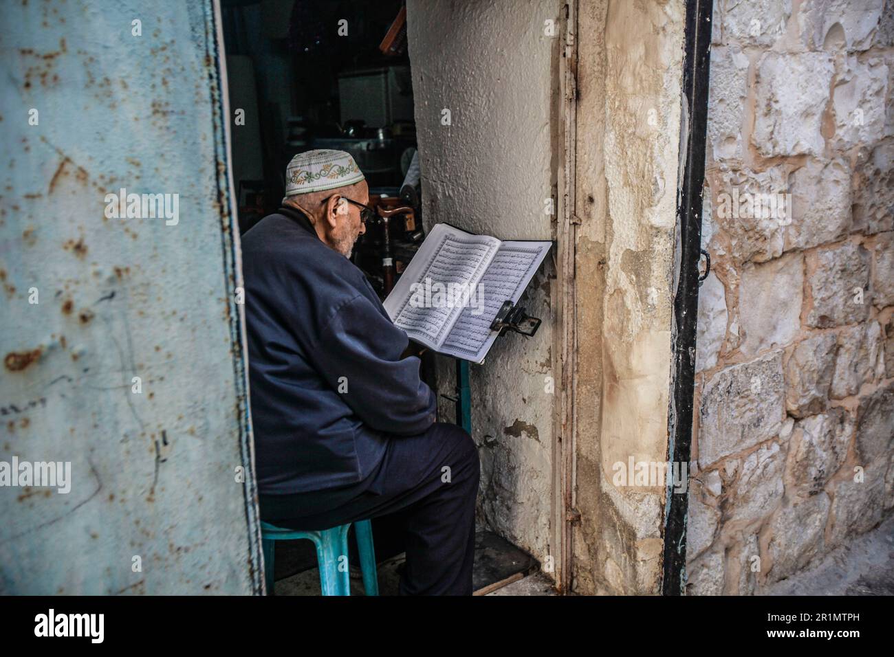 Nablus, Palästina. 14. Mai 2023. Ein alter Palästinenser liest den Koran in seinem Haus in der Altstadt von Nablus, nördlich des besetzten Westjordanlands. Kredit: SOPA Images Limited/Alamy Live News Stockfoto